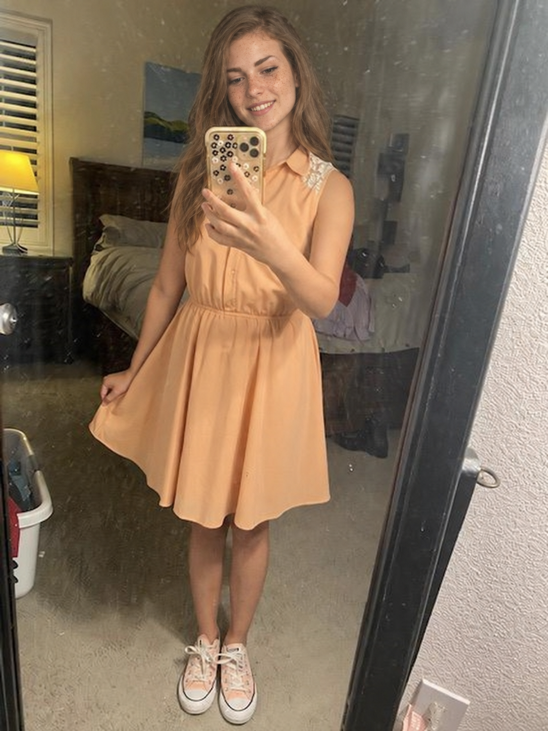 Nell taking a mirror photo in a peach dress