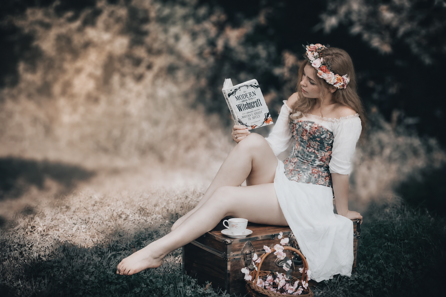 Nell reading while seated on an old trunk